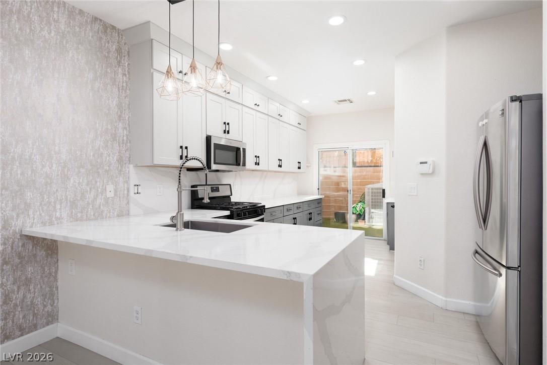 Image 1: A streamlined modern kitchen with crisp white cabi