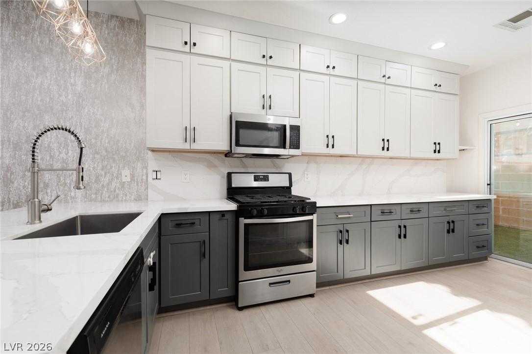 Image 2: A well-lit kitchen boasts elegant two-toned cabine