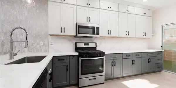 Image 2: A well-lit kitchen boasts elegant two-toned cabine