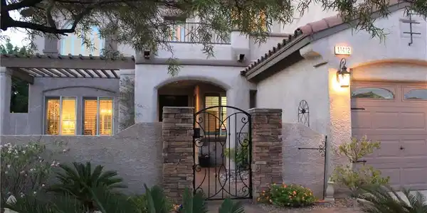 Image 2: Ornate wrought iron gate and stone pillars lead to