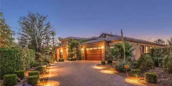 Image 4: An inviting brick paver driveway leads to a warm,