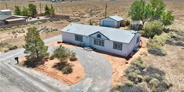 Image 3: A detached garage with ample gravel parking offers