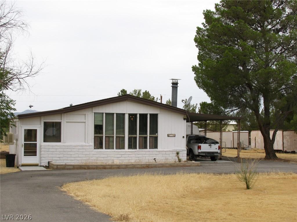 Image 3: A classic facade with a covered carport provides p
