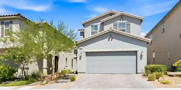 Image 2: A well-maintained facade with an attached garage a