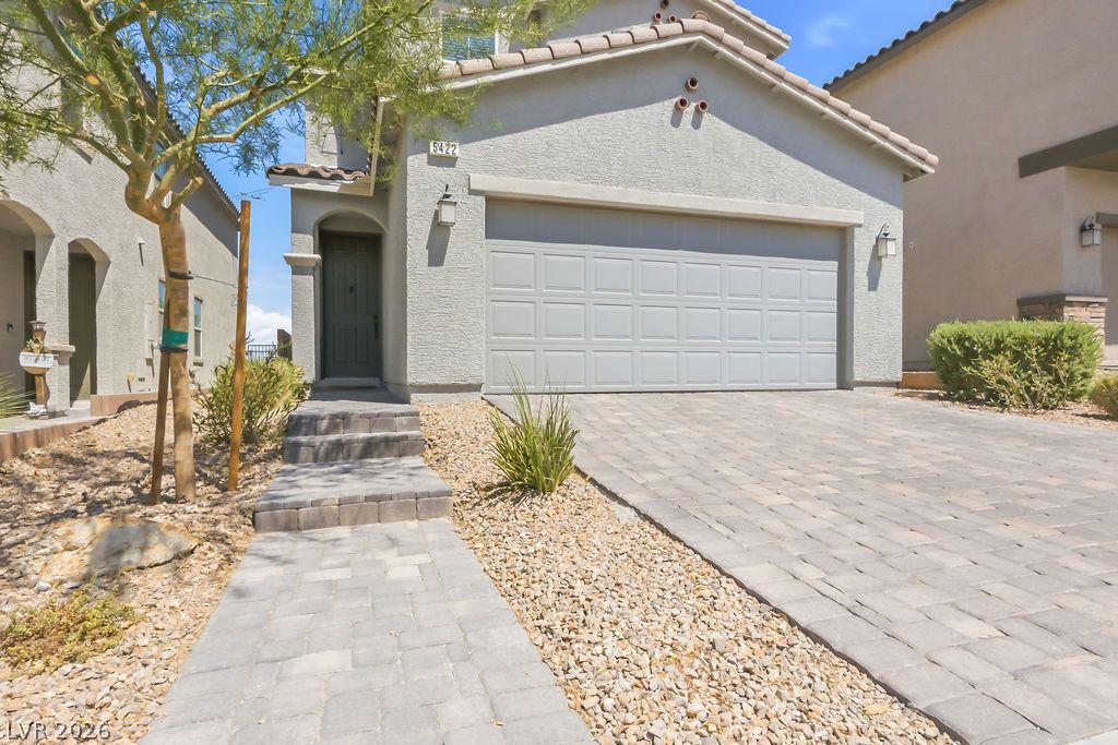 Image 4: A paver driveway and walkway lead to the welcoming