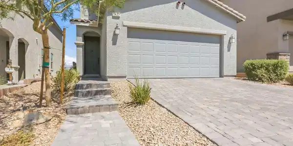 Image 4: A paver driveway and walkway lead to the welcoming