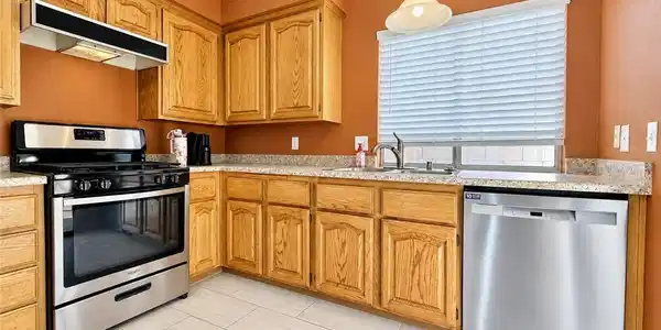 Image 2: Ample wooden cabinetry and stone-look counters hig
