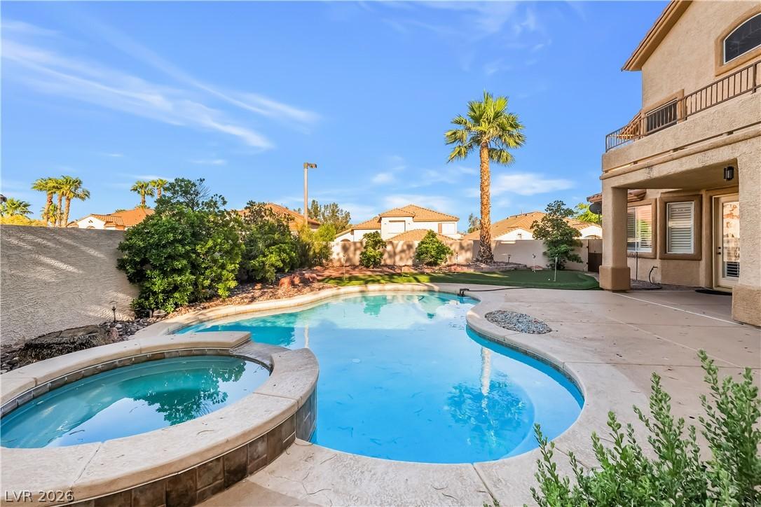 Image 3: An inviting backyard oasis offers a freeform pool