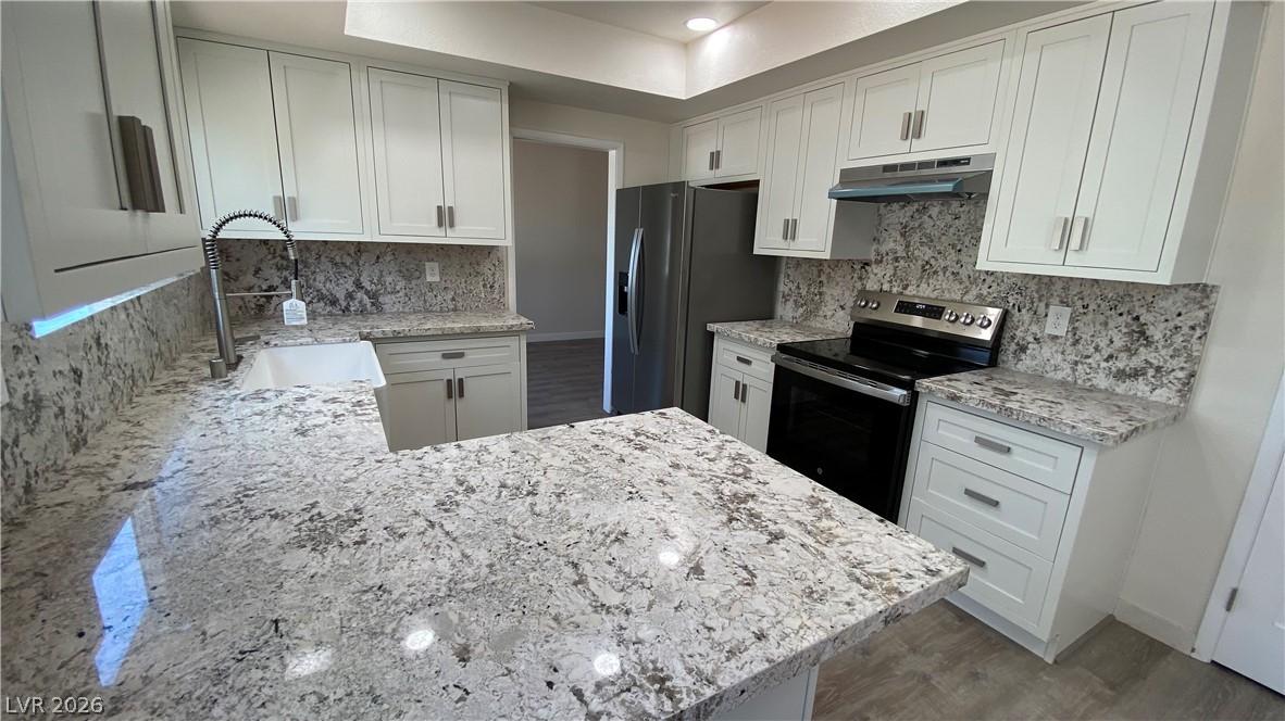 Image 3: This modern kitchen features gleaming granite coun