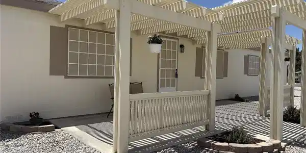 Image 3: A charming pergola provides a shaded entry to this