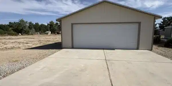 Image 4: A detached garage provides ample storage, compleme