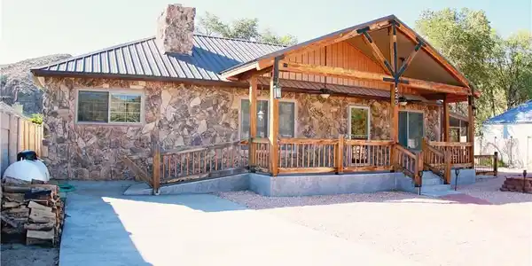 Image 2: Rustic stone and wood home featuring an inviting c