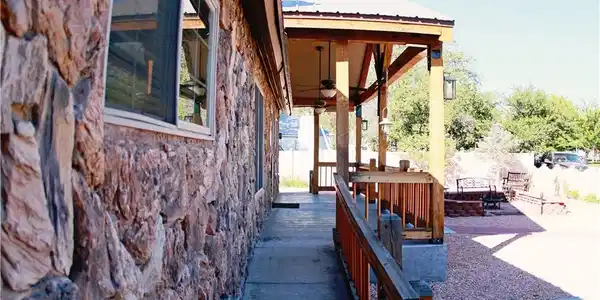 Image 3: A stone-clad facade meets a welcoming covered porc