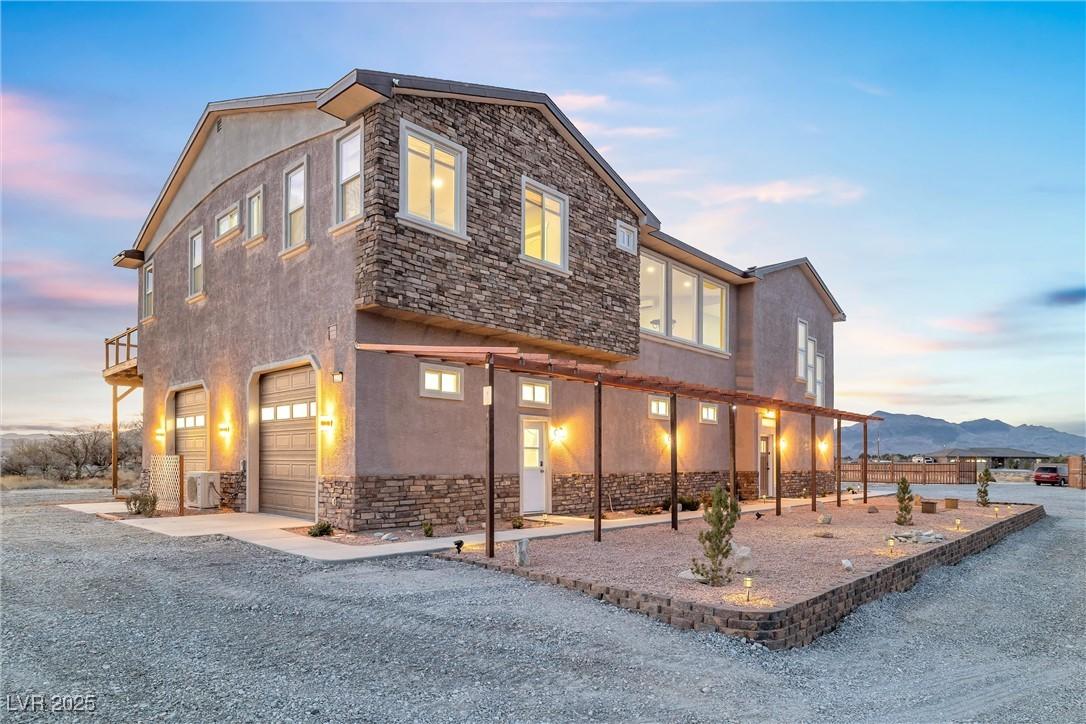 Image 2: View of front of home featuring stone siding, stuc