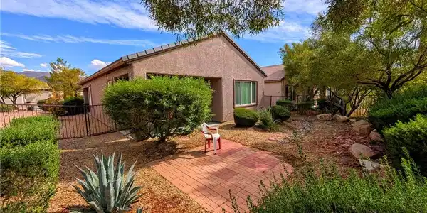 Image 2: Lush desert landscaping surrounds a brick patio in