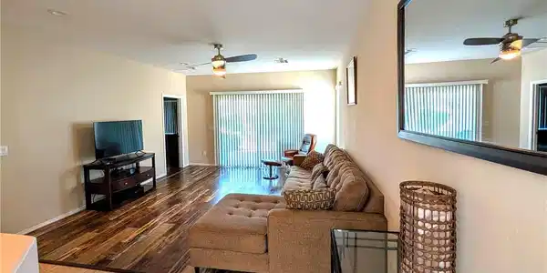 Image 3: Richly toned wood flooring sweeps through an open