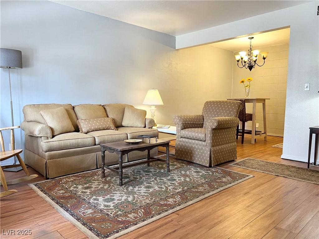 Image 3: Living room with a notable chandelier and wood fin