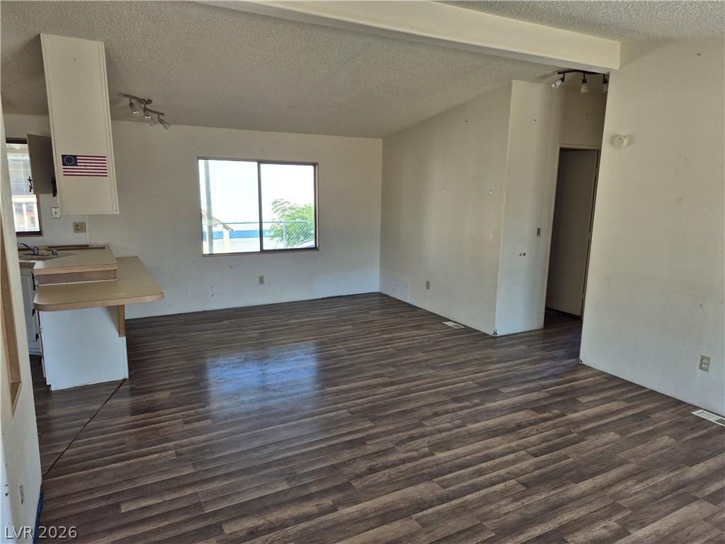 Image 3: An open floor plan with rich wood flooring awaits