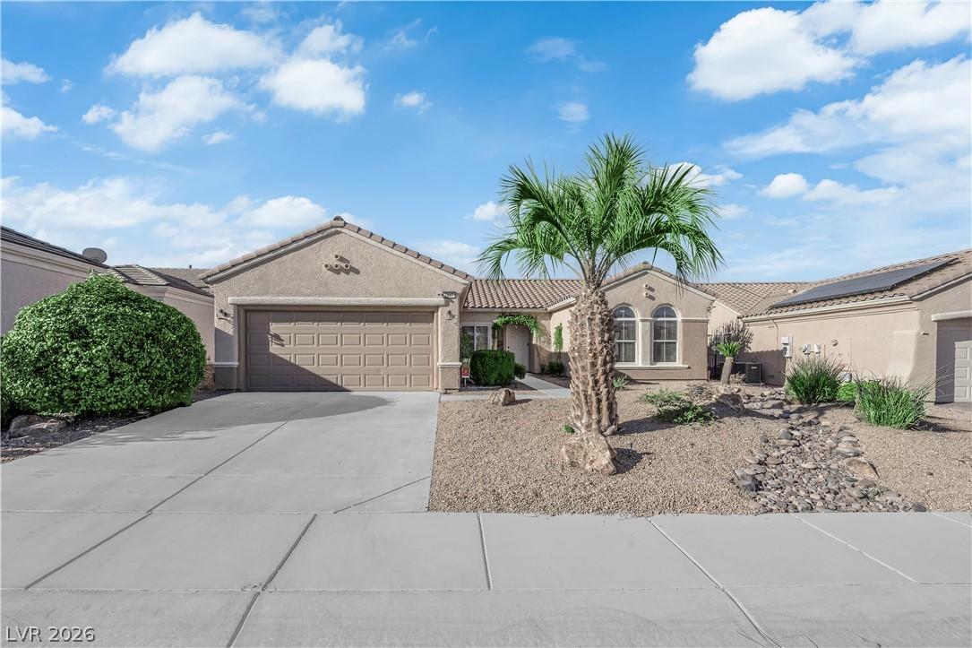 Image 1: A well-maintained stucco home with a desert-friend