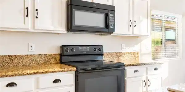 Image 3: A well-appointed kitchen features ample white cabi