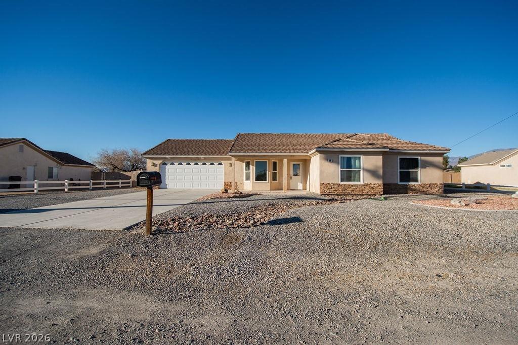 Image 1: View of front facade with stone siding, concrete d