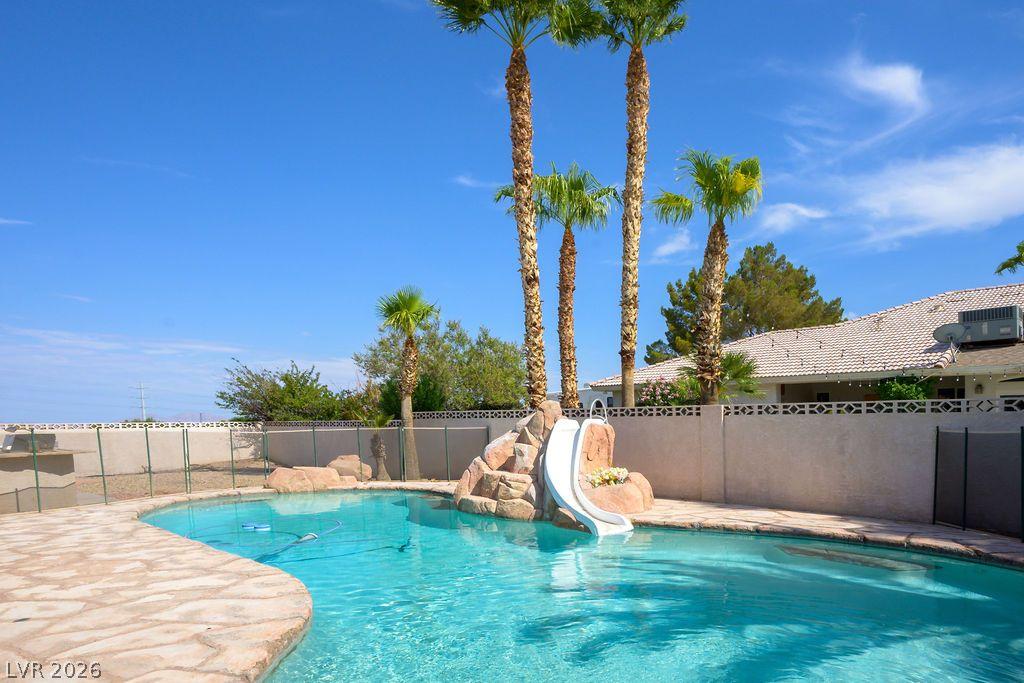 Image 4: A private, resort-style backyard offers a sparklin