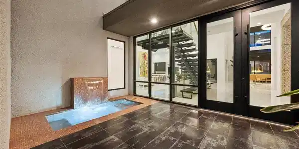 Image 4: An inviting water feature and sleek glass doors le
