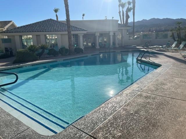 Image 2: A sparkling pool invites relaxation, set against a