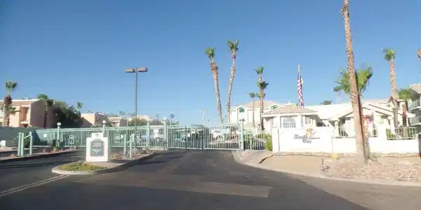 Image 4: Secure community entrance with palm trees and a we