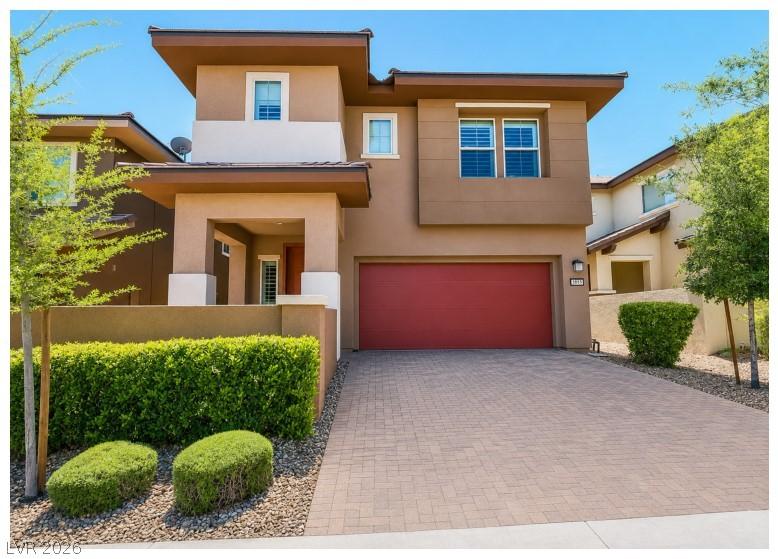 Image 2: This modern home features a paved driveway and an