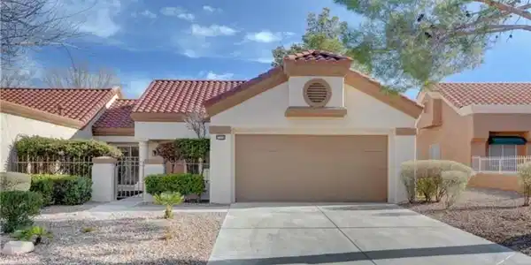 Image 3: A well-maintained stucco home with a tile roof and