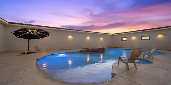 Image 3: Pool at dusk featuring a patio area