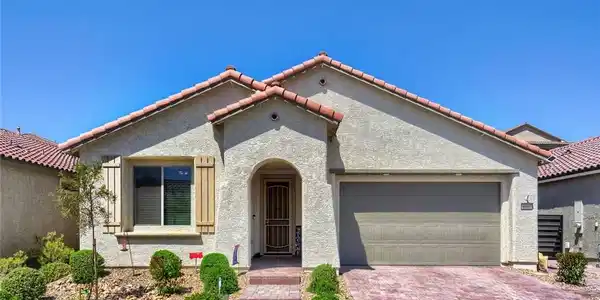 Image 2: This appealing stucco home features a tiled roof a