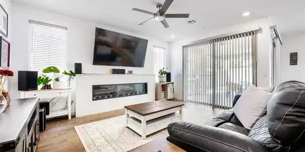 Image 4: This living room features a fireplace and wood-loo