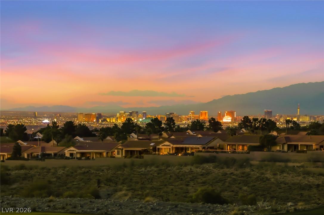 Image 1: Dramatic sunset over a neighborhood with city ligh