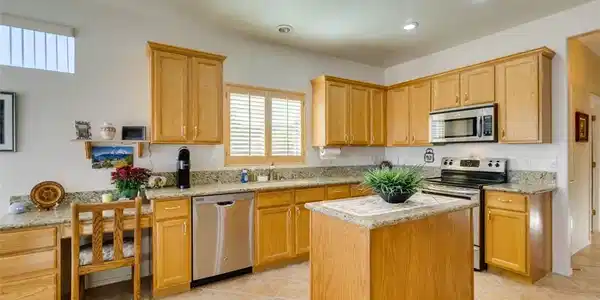 Image 4: Warm wood cabinetry and granite countertops anchor