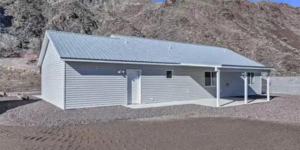 Image 4: A modern home nestled against a rugged mountain la