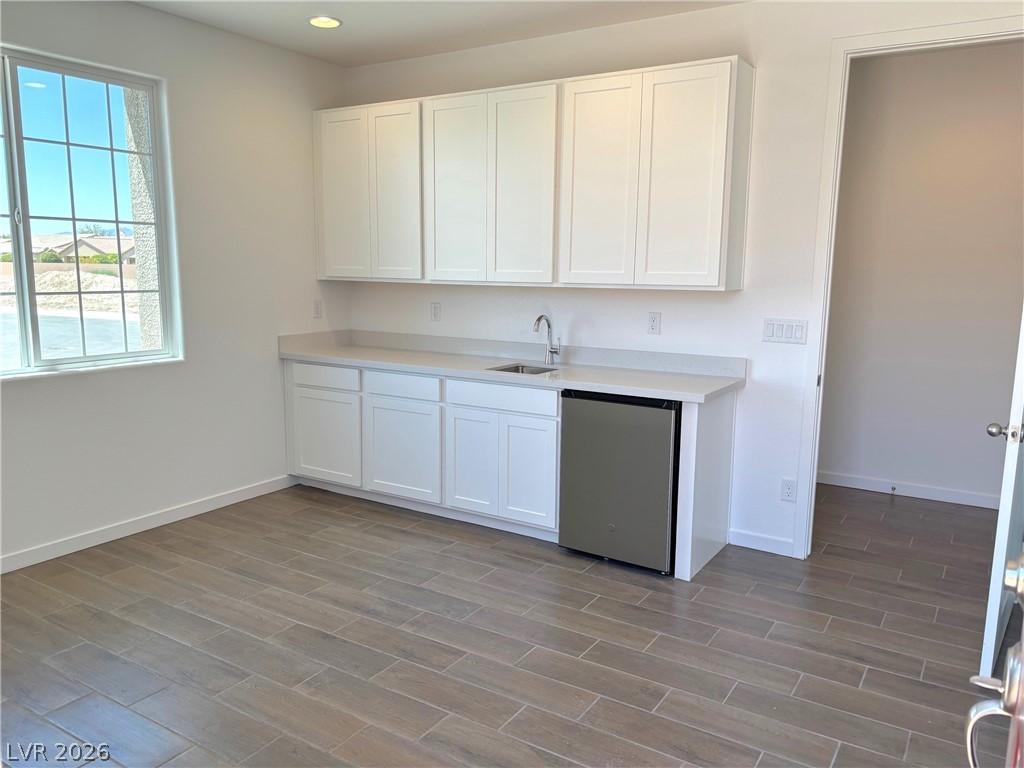 Image 4: Kitchen with dishwasher, white cabinets, wood tile