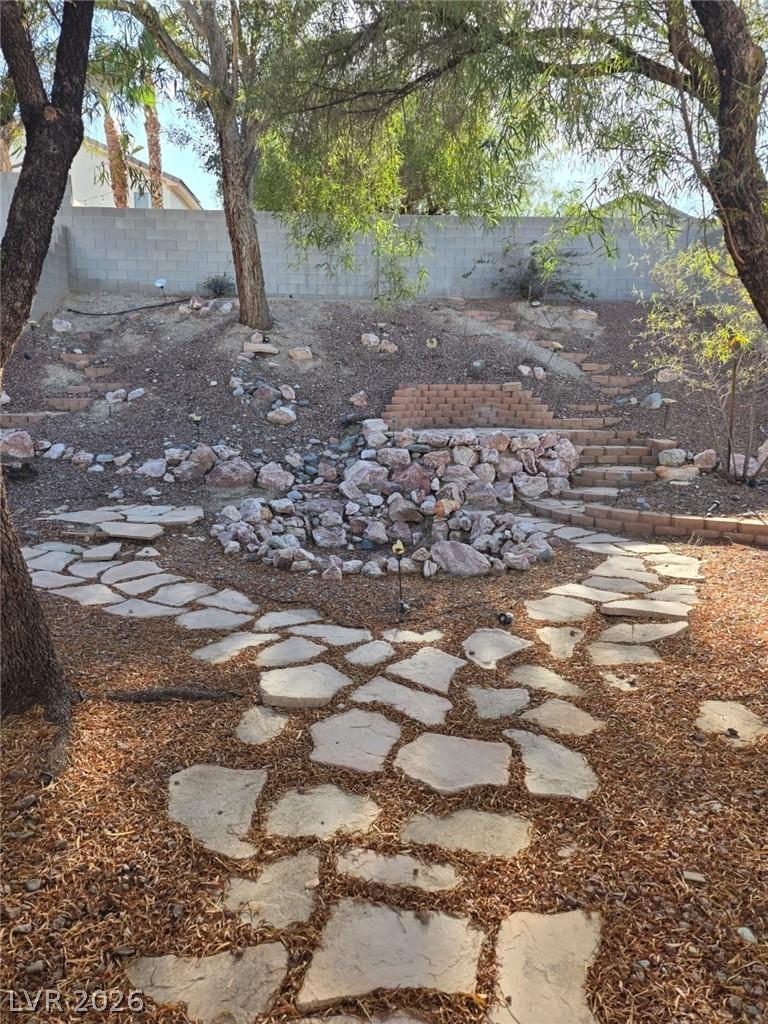 Image 3: A tranquil backyard oasis features flagstone pathw