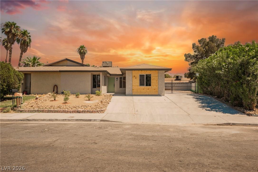 Image 3: Concrete driveway leads to a modern facade with na