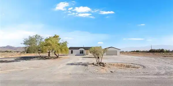 Image 4: A spacious gravel driveway leads to this charming