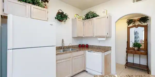 Image 3: An arched doorway leads to the tiled kitchen featu