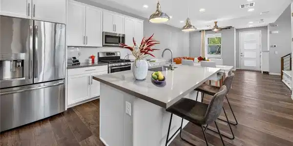 Image 4: Rich wood flooring anchors this open kitchen layou