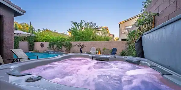 Image 3: An inviting hot tub overlooks the sparkling backya