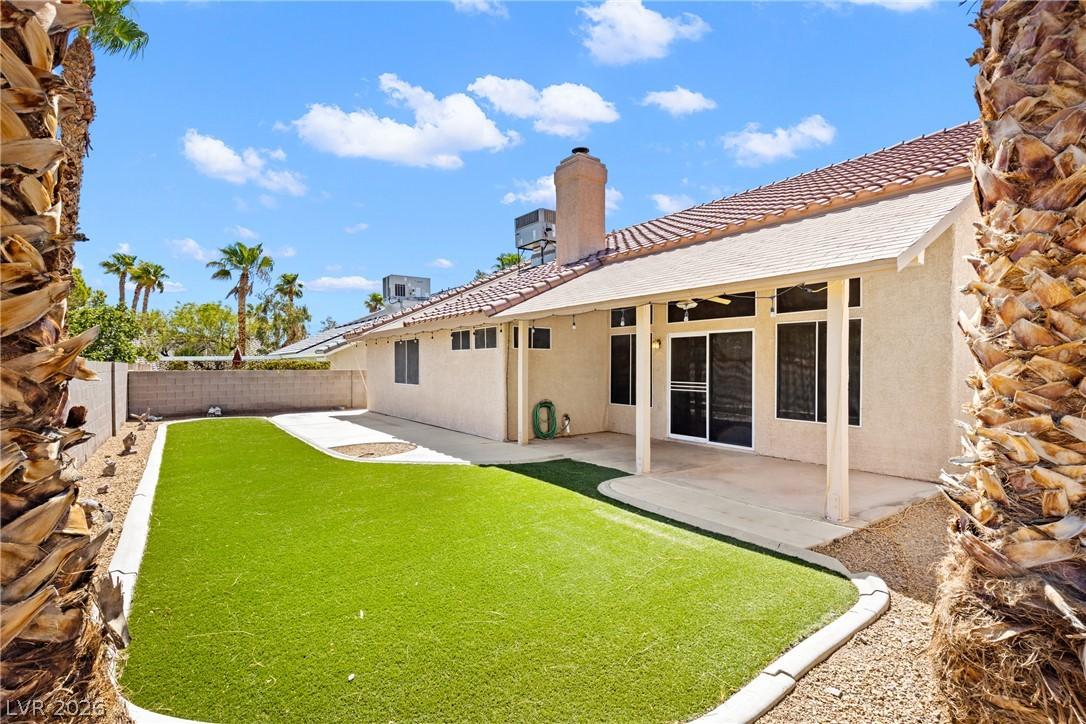 Image 3: Maintained artificial turf and a covered patio for