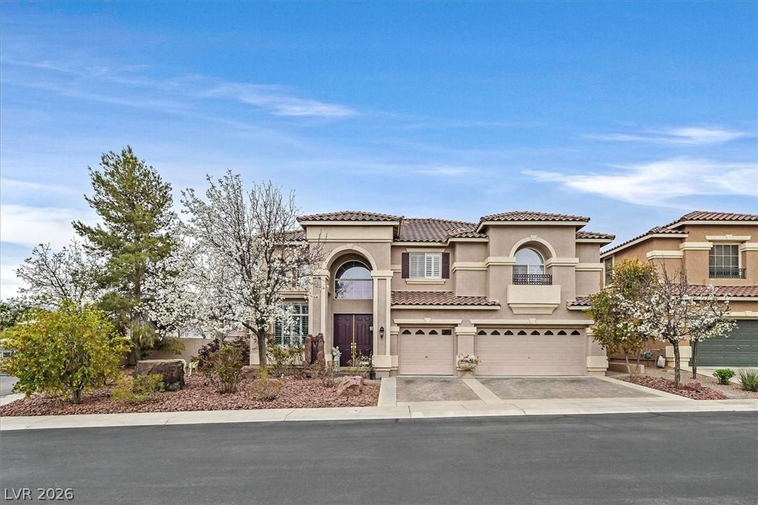Image 2: A stately stucco residence with a tile roof and ar