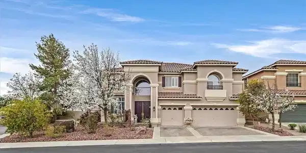 Image 2: A stately stucco residence with a tile roof and ar
