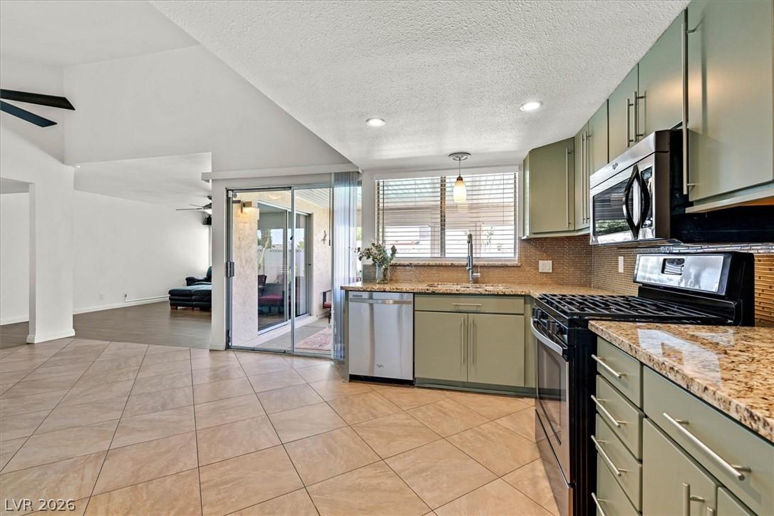 Image 2: A well-equipped kitchen with tile flooring and a v