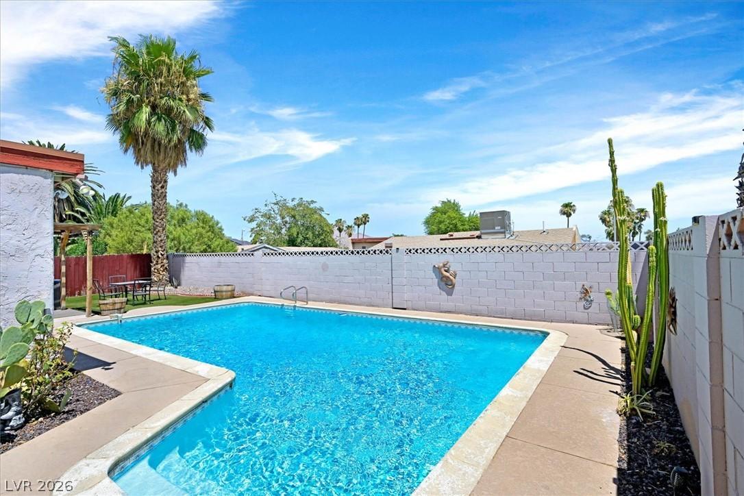 Image 3: An inviting backyard oasis offers a sparkling in-g