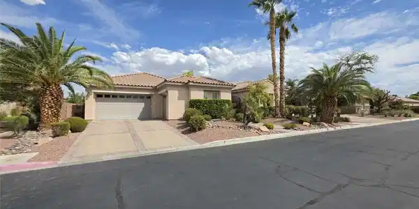 Image 2: Desert landscaping and mature palm trees frame thi